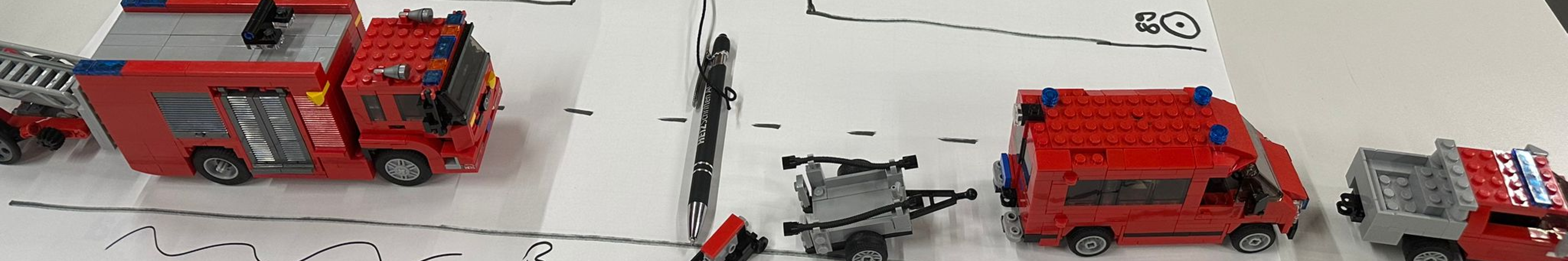 LEGO®-Modelle unserer Fahrzeuge auf einem aufgemalten Strassenplan